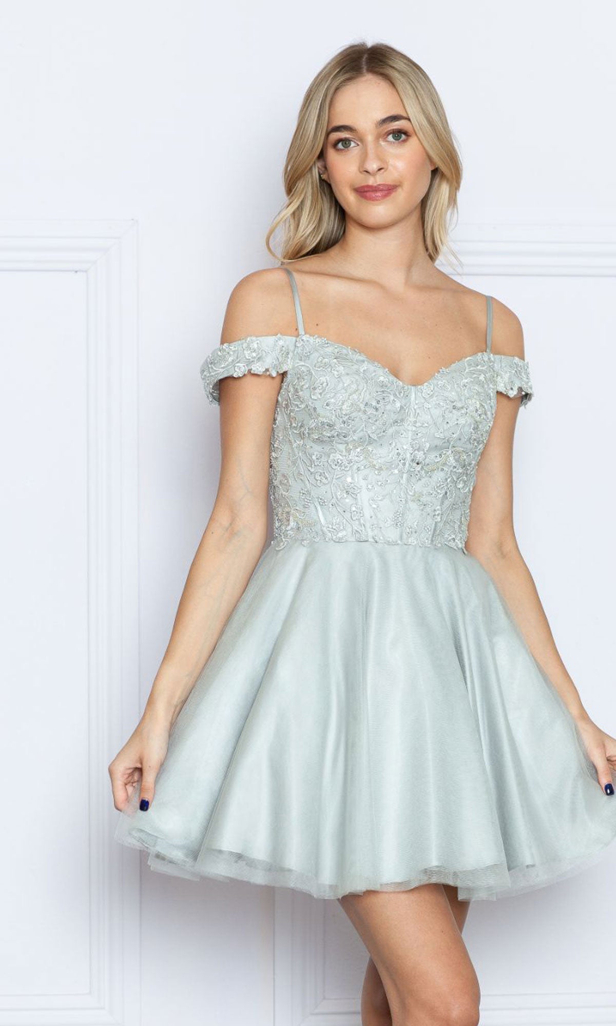 A young woman models the Lace-Up Off-Shoulder Short Babydoll Hoco Dress9234, featuring a light blue, fitted embroidered bodice and flared skirt, standing against a plain white background.